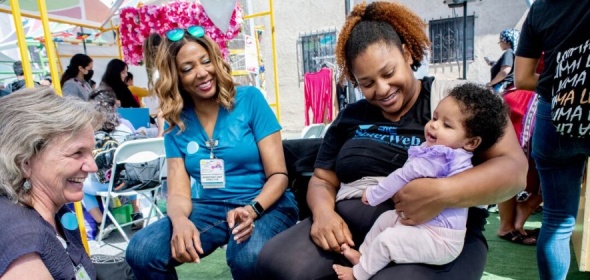 Photo of laughing women with baby at UCSF community health fair.