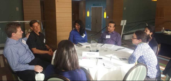 Photo of physician leaders at a table discussing Healthforce Center's physician leadership development.