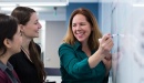 Photo of instructor with students at a whiteboard